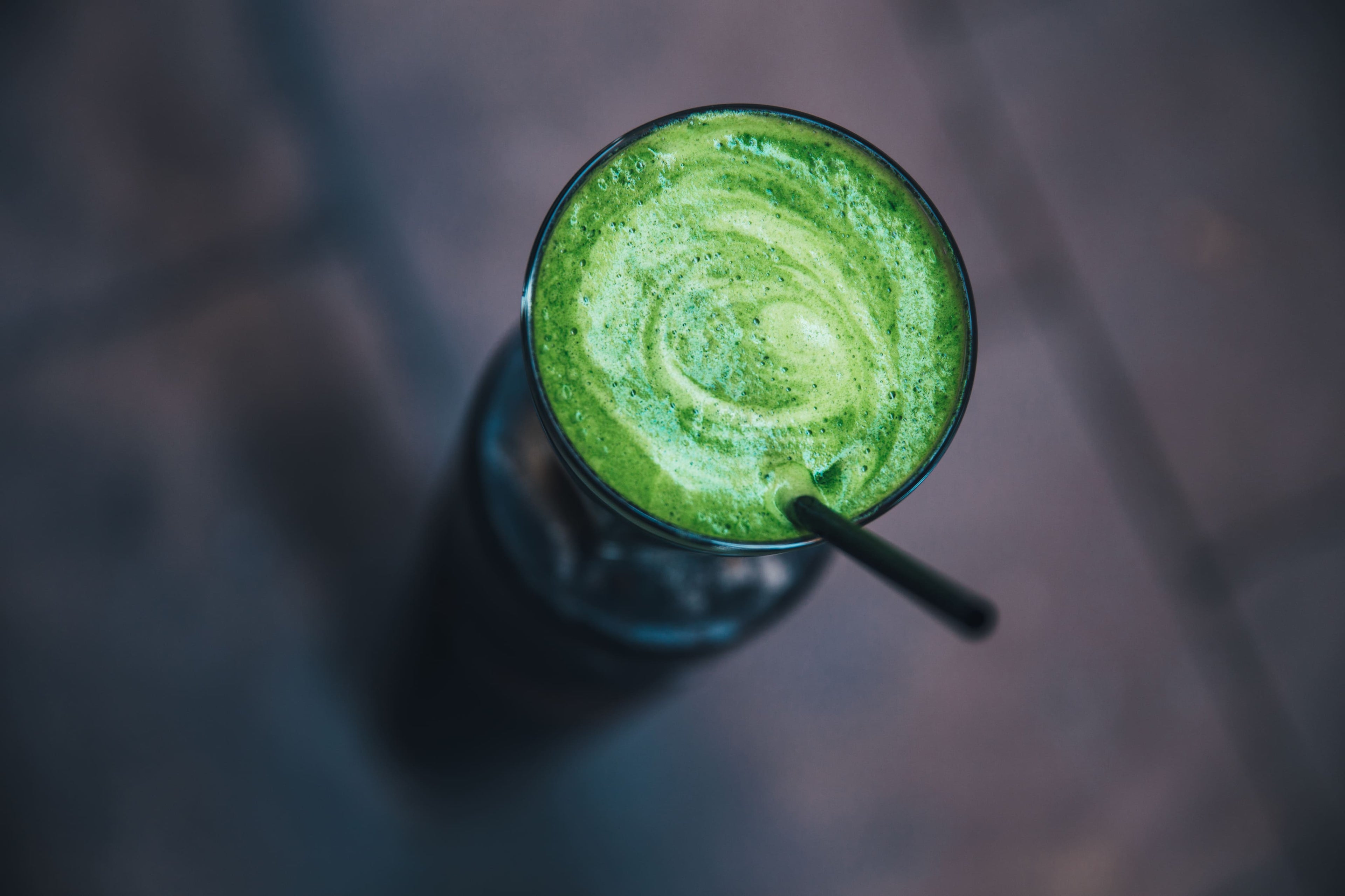 Top view of a vibrant green healthy detox smoothie in a glass